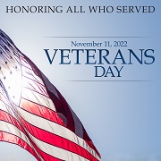 Veterans Day. November 11, 2022. Honoring all who served. American flag waves to the side.
