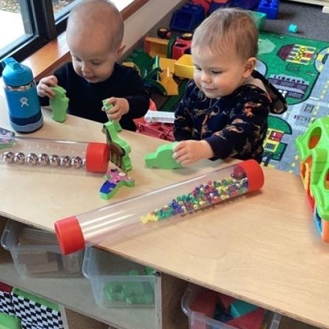 Two toddlers play at a table inside the Capitol Campus Childcare Center