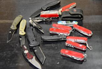 A variety of pocket knives displayed on a table