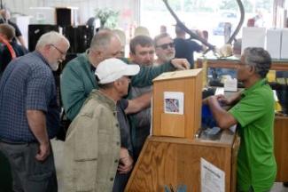 People viewing an item at the Surplus Grand Re-opening event. 