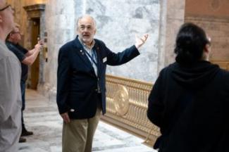 Volunteer Dick Van Wagenen leads a tour group inside the Legislative Building. 