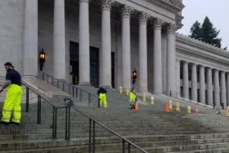 Workers cleaning steps of the Legislative Building. 