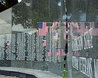 A small American flag left by a visitor portrudes from the wall of the Vietnam Veterans memorial.