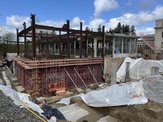 The Joel Pritchard State Library construction site as of April 11, 2025. The site consists of steel beams, scaffolding, and other stone and metal materials.