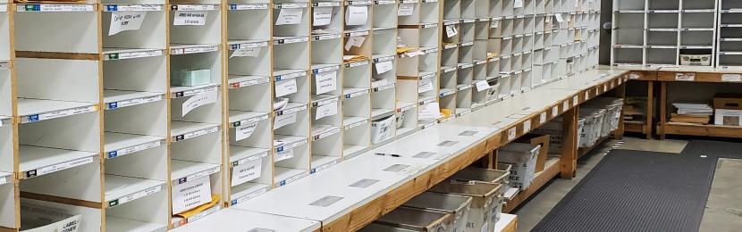 The mail room's sort wall containing hundreds of cubbies for incoming and outgoing mail. 